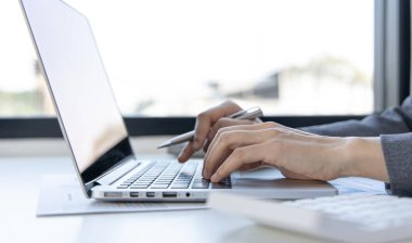 Bilgisayarın klavyesine, teknoloji ve internet iletişimine basan bir kadının yakın plan fotoğrafı. Finans uzmanları emlak gelirlerini hesaplamak ve kontrol etmek için dizüstü bilgisayar kullanıyor..