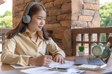 Asyalı kadın internet üzerinden neşeli bir gülümsemeyle çalışıyor, evde kalıyor, Yeni Normal, Covid-19 Coronavirus, Sosyal Mesafe, İnternet Öğrenimi.