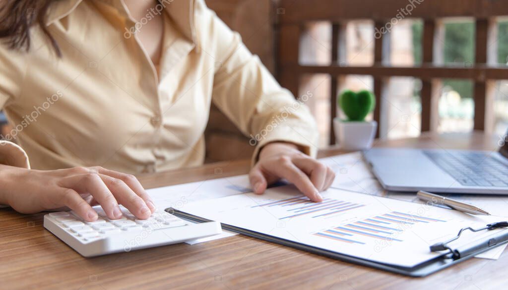 Financial businesswoman calculating corporate income tax data And analyzing charts of financial stocks that are in good condition with growth and progress, Investment in finance and accounting industries.