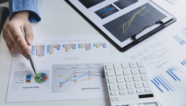 Finans işadamı şirketin kâr ve büyüme, piyasa araştırma raporları ve gelir istatistikleri, Finansal ve Muhasebe kavramları yaratma performansının grafiğini analiz ediyor.