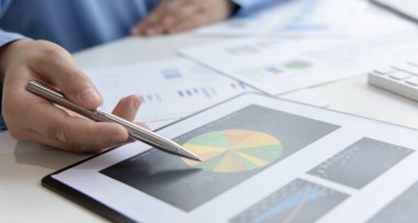 Finans işadamı şirketin kâr ve büyüme, piyasa araştırma raporları ve gelir istatistikleri, Finansal ve Muhasebe kavramları yaratma performansının grafiğini analiz ediyor.
