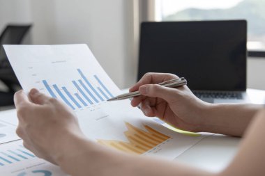 Finans işadamı şirketin kâr ve büyüme, piyasa araştırma raporları ve gelir istatistikleri, Finansal ve Muhasebe kavramları yaratma performansının grafiğini analiz ediyor.