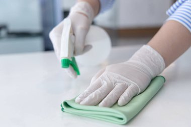 Personel el elini kapatın. Restoran çalışanları virüs salgını sırasında masaları temizliyor ve dezenfektanları püskürtüyor, temizlik çözümleri kullanıyor ya da restorandaki mikropları öldürmek için alkol kullanıyor..