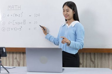 Asyalı üniversite öğretmenleri internet üzerinden canlı kayıt yapmak için akıllı telefonla matematik öğretiyor. Virüs salgını, çevrimiçi uzaktan öğrenme ve insanlar için karantina nedeniyle uzun mesafe çalışması..