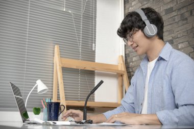 Asyalı üniversite öğretmenleri internet üzerinden canlı kayıt yapmak için dizüstü bilgisayarla matematik öğretiyor. Virüs salgını, çevrimiçi uzaktan öğrenme ve insanlar için karantina nedeniyle uzun mesafeli çalışma..