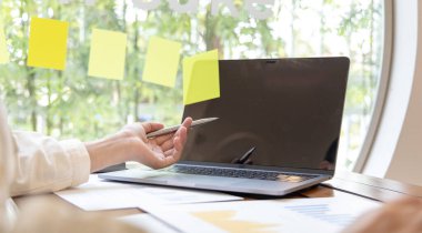 Finans işkadınları, pazarlama stratejileri ve emlak verilerini analiz etmek için dizüstü bilgisayar kullanarak müşterileri, muhasebe ve vergi kavramlarının şirket vergilerini düşürürler..