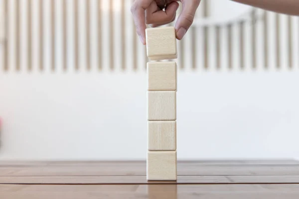 Arrange the wooden blocks into steps, higher the marketing strategy the more effort is required, Ladder of success, Driving business at the peak concept.