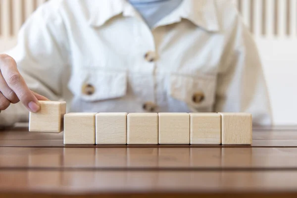 Arrange the wooden blocks into steps, higher the marketing strategy the more effort is required, Ladder of success, Driving business at the peak concept.