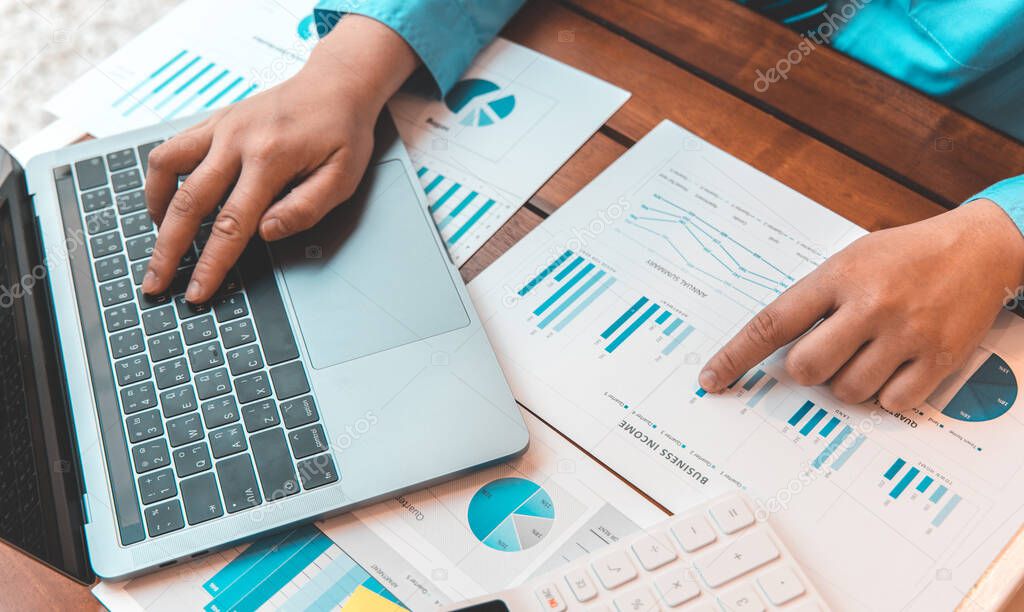 Financial businessmen use laptop to analyze marketing strategies and real estate data to reduce company taxes for their customers, Accounting and Tax concept.