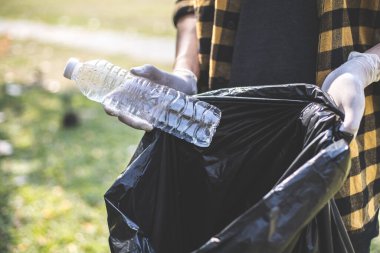 Erkek gönüllüler, parka düşen su şişelerini ya da plastik torbaları taşıyorlar. Çöp tenekelerine, çevre korumasına ya da geri dönüşümle atık imhası için gönüllü oluyorlar..