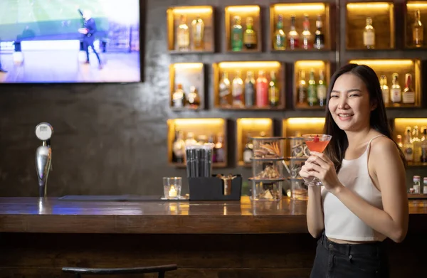 Asian alone women enjoy cocktails in front of a vintage bar, Relaxing activities after work or hangouts, Place of entertainment for young adolescents or night club party.