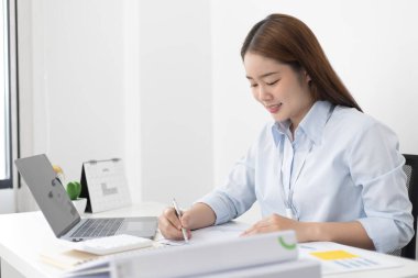 Asyalı kadınlar grafikleri, pazar verilerini ve yatırım risklerini analiz ediyor, virüs salgını veya sosyal alanlarda evde çalışıyor, mikropları yaymaktan kaçınıyor.