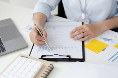 Asyalı kadınlar grafikleri, pazar verilerini ve yatırım risklerini analiz ediyor, virüs salgını veya sosyal alanlarda evde çalışıyor, mikropları yaymaktan kaçınıyor.