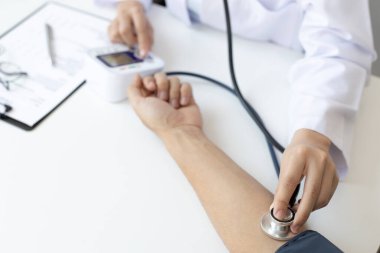 Kadın doktorlar kalp atışlarını ölçmek için kan basıncı monitörleri ve steteskop kullanırlar. Hastanın hastalığını modern bir hastane laboratuvarında, tıbbi tedavi ve sağlık konseptinde teşhis ederler..