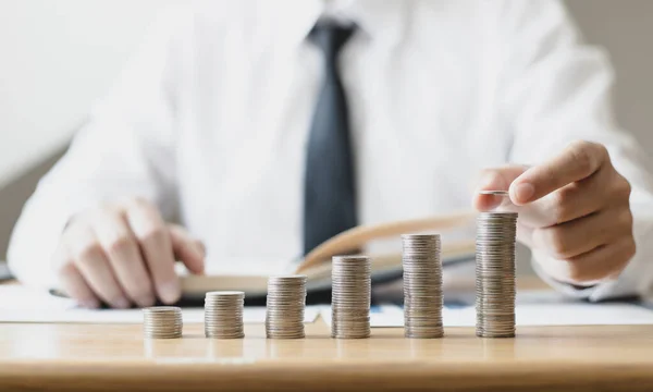 Man's hands put the coins arranged in steps, Managing your finances or saving money for future use, Saving for investment, Saving money for business growth or long-term profitability.