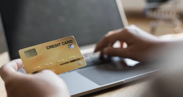 Woman's finger presses a keyboard and holds a credit card to register for payment or online transactions, Financial transactions and Internet security, Shopping online and banking online concept.