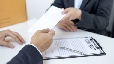 Çalışan, yanında bir kutu iş malzemesi ve bir zarf getirdi. Kadın, istifa belgelerini amirlerine sundu ve ofisteki kahverengi bir kutuda kişisel ekipmanlarını aldı..