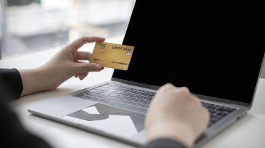 Çevrimiçi ürün alımı, İş kadını online alışveriş, alışveriş ve posta, kredi kartı çevrimiçi güvenlik, çevrimiçi alışveriş konsepti yapmak için kredi kartlarıyla dizüstü bilgisayarı kullanır.