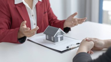 Emlakçı ya da satış müdürü ev satışları teklif etti ve ev satın alma sözleşmesi ve ücretsiz ev sigortası, finans ve satış sonrası hizmet kavramını açıkladı..