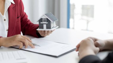 Emlakçı ya da satış müdürü ev satışları teklif etti ve ev satın alma sözleşmesi ve ücretsiz ev sigortası, finans ve satış sonrası hizmet kavramını açıkladı..