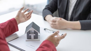 Emlakçı ya da satış müdürü ev satışları teklif etti ve ev satın alma sözleşmesi ve ücretsiz ev sigortası, finans ve satış sonrası hizmet kavramını açıkladı..