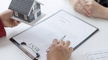 Emlakçı ya da satış müdürü ev satışları teklif etti ve ev satın alma sözleşmesi ve ücretsiz ev sigortası, finans ve satış sonrası hizmet kavramını açıkladı..