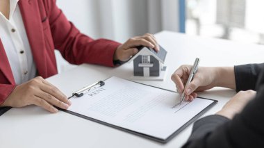 Ev satın alma sözleşmesi imzalayan satış müdürü, ev satın alma anlaşmalarını sigorta ile imzalayan müşterilere satış sözleşmesini imzalama şartlarını ve şartlarını önerdi..