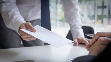 İşçi, yanında bir evrak zarfı ve bir kutu iş malzemesi getirdi. İş adamı, istifa belgelerini müdürüne sundu ve ofisten kahverengi bir kutuda kişisel ekipmanlarını aldı..