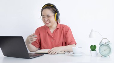 Genç Asyalı kadınlar video sohbetleri yoluyla arkadaşlarını ve öğretmenlerini selamlıyor ve onları neşeli ifadelerle karşılıyor, Online iletişim, Evde kal, Yeni Normal, Covid-19 Coronavirus, Sosyal Mesafe, İnternet Öğrenimi.