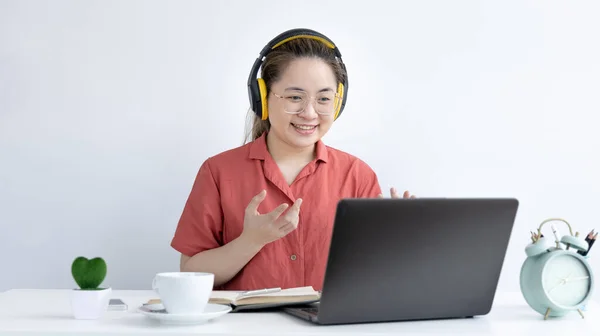 Young Asian women are greeting friends and teachers through video chats and greeting them with cheerful expressions, Online communication , Stay home, New normal, Covid-19 coronavirus, Social distancing, Internet learning.