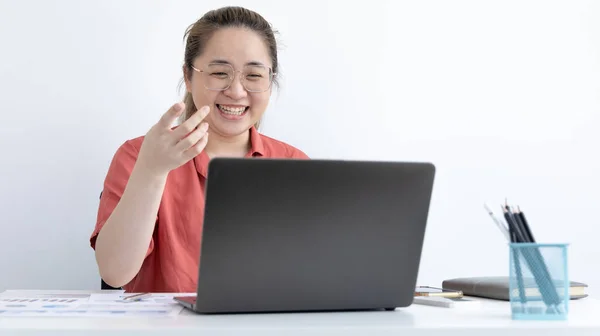 Young Asian women are greeting friends and teachers through video chats and greeting them with cheerful expressions, Online communication , Stay home, New normal, Covid-19 coronavirus, Social distancing, Internet learning.