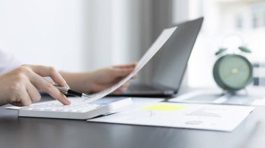 Genç Asyalı iş kadını, emlak yatırımcılarının gelir vergisi ve kurumsal gelirlerini hesaplamak için özel bir ofis, Finans, Muhasebe, Tex, İstatistiksel grafikleri ve emlak yatırımlarının hesap makinesine baskı yapıyor..