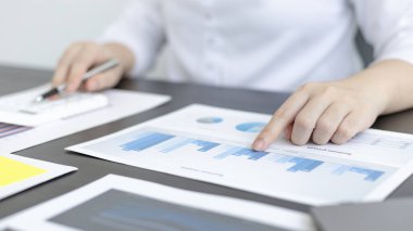 Genç Asyalı iş kadını, emlak yatırımcılarının gelir vergisi ve kurumsal gelirlerini hesaplamak için özel bir ofis, Finans, Muhasebe, Tex, İstatistiksel grafikleri ve emlak yatırımlarının hesap makinesine baskı yapıyor..