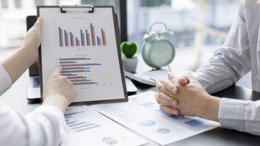 Beyin fırtınası ekibi, pazarlamacılar ve finans muhasebecileri müşteri ihtiyaçlarını karşılamak için stratejiler planlamak, grafikler ve dizüstü bilgisayarları kullanarak iş verilerini analiz etmek ve konsepti karşılamak için grafikleri tartışıyor ve analiz ediyorlar..