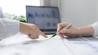 Beyin fırtınası ekibi, pazarlamacılar ve finans muhasebecileri müşteri ihtiyaçlarını karşılamak için stratejiler planlamak, grafikler ve dizüstü bilgisayarları kullanarak iş verilerini analiz etmek ve konsepti karşılamak için grafikleri tartışıyor ve analiz ediyorlar..