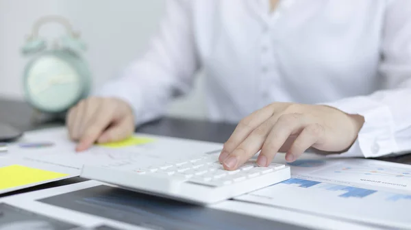 Young Asian businesswoman presses a calculator to calculate income tax and corporate income in a private office, Finance, Accounting, Tex, Statistical graphs of marketers investing in real estate.