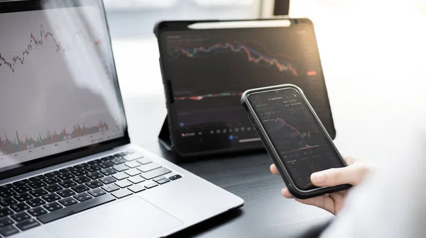 Genç bir iş kadınının elinde borsa verilerinin grafiği olan bir telefon var ve borsa kazanımını ve zararını analiz ediyor. Borsa verilerinin analizi için bu anlaşmayı yapın..