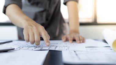 Mimari bina tasarımı ve planlı inşaat planları, genç adam cetvel, kalem, mezura, mimar şapkası ve diğer ekipmanlarla bir bina veya mimari tasarlıyordu..