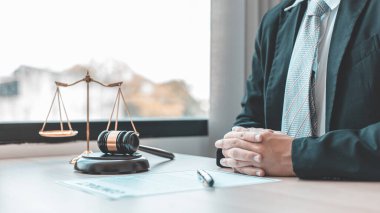 Erkek avukat ya da hakim davayı değerlendirir ve adil bir şekilde karar verir, masada adalet terazisi ve dürüst yargı, hukuk kavramları ve hukuk hizmetleri vardı..