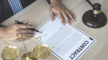 Avukatlar veya hakimler, yasal ve adil anlaşma, hukuki ahlak ve bütünlük, adalet terazisi, hukuki çekiç, dava ve hukuk hizmetleri çerçevesinde belgeleri imzalıyorlar..