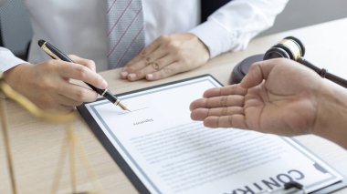 Avukat ya da hakim, müvekkilinin mahkeme salonunda, yasal anlaşma belgelerinde ve iş hukuku davaları formlarında, adalet terazisinde, hukuk çekicinde, davalarda ve hukuki hizmetlerde yasal bir anlaşma imzalamasını öneriyor..