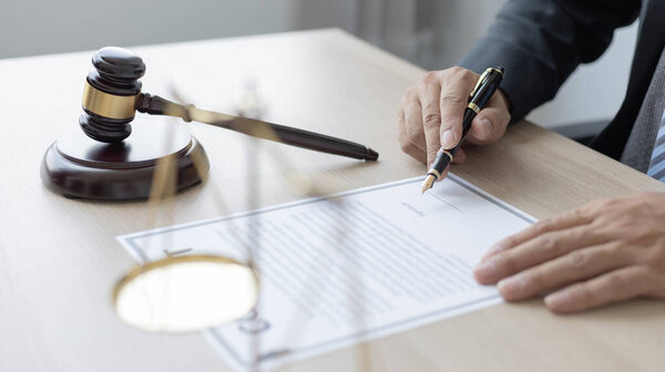 Lawyers or judges sign documents in accordance with legal and fair terms of agreement, Legal Ethics and Integrity, scales of justice, law hammer, Litigation and legal services.