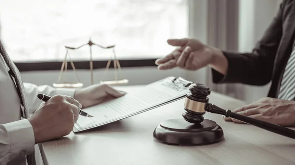 Lawyer or judge has recommend a client sign a legal agreement in the courtroom, Legal Agreement Documents and Business Litigation Forms, scales of justice, law hammer, Litigation and legal services.