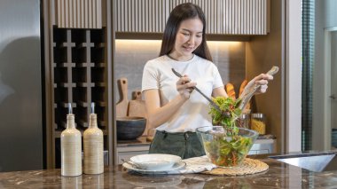 Ev mutfağında sebze salatası yapan Asyalı kadın çeşitli vitamin ve mineraller, yüksek lifli ve düşük kalorili diyetler, sağlıklı sebze salatası fikri, aperatif konsepti içeriyor..