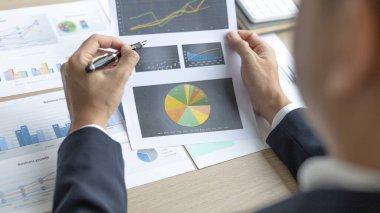 Finans işadamı şirketin kâr ve büyüme, piyasa araştırma raporları ve gelir istatistikleri, Finansal ve Muhasebe kavramları yaratma performansının grafiğini analiz ediyor.