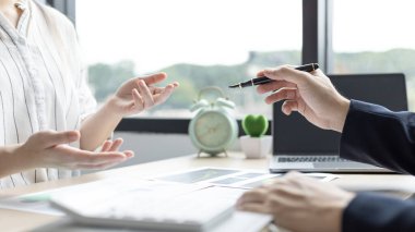 Beyin fırtınası ekibi, pazarlamacılar ve finans muhasebecileri müşteri ihtiyaçlarını, takım toplantılarını veya iş danışmanlığını karşılayacak stratejiler planlamak ve analiz etmek için grafikleri tartışıyor..