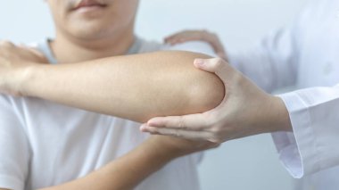 Fizik tedavi, kadın fizyoterapist kliniğe giden bir erkek hasta için kol ve omuz ağrısı, kemik aranjmanı, cerrahi olmayan tıbbi tedavi, modern tıbbi teknikler..