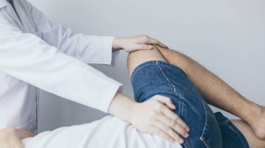 Fizik tedavi, kadın fizyoterapist, kliniğe giden bir erkek hasta için bacak ve kalça ağrısı, kemik aranjmanı, cerrahi olmayan tıbbi tedavi, modern tıbbi teknikler..