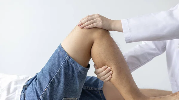 物理疗法 女性理疗师治疗在诊所就诊的男性病人的腿和髋关节疼痛 骨排列 非外科医疗 现代医疗技术 — 图库照片