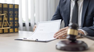 Avukatlar veya hakimler, yasal ve adil anlaşma, hukuki ahlak ve bütünlük, adalet terazisi, hukuki çekiç, dava ve hukuk hizmetleri çerçevesinde belgeleri imzalıyorlar..